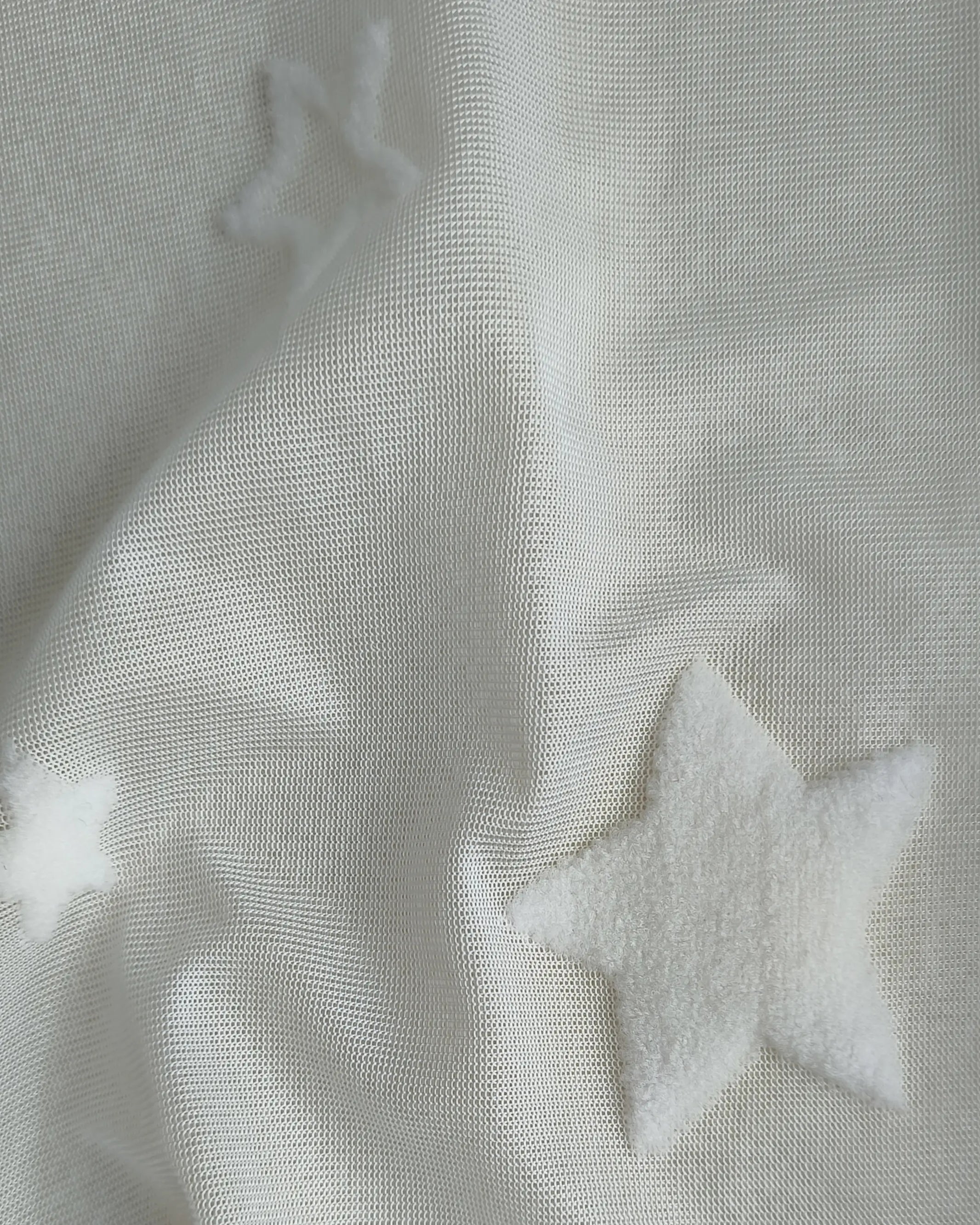 White textured pleated curtains with patterned design, perfect for the living room.