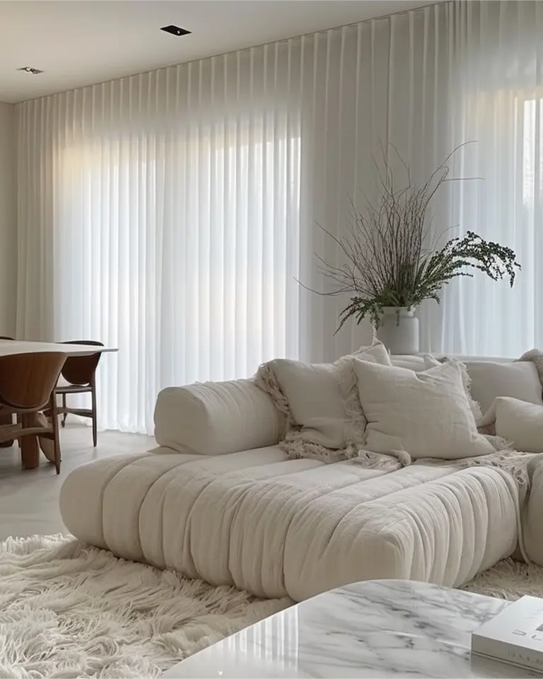White silk grommet curtains are installed on rods in the living room.