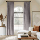 Grey curtains blending linen, cotton, and polyester with black curtain rods, adding elegance to the living room.