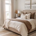 Neutral bedroom with beige curtains, cozy bedding, and warm-toned pillows, featuring natural light from large windows.