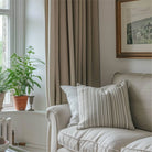 The living room features soft top, linen-colored and polyester pleated curtains hanging on rods.