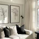 Modern living room with white drapery, black and white pillows, and minimalist tree art on the wall.