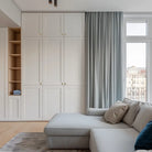 Cozy living room with light blue drapery, white cabinetry, and a comfortable sectional sofa.