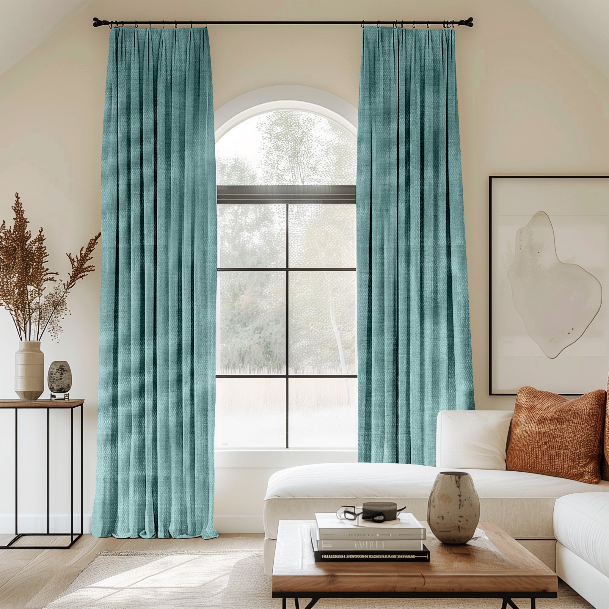 Living room with arched window and aqua velvet pleated curtains.