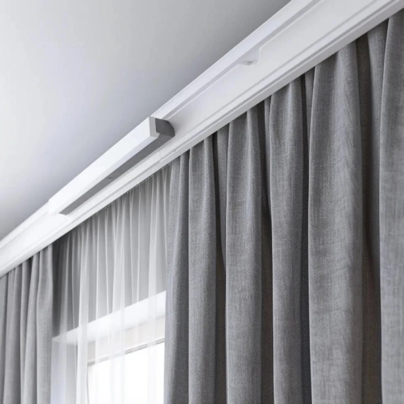 Modern curtain track with gray drapery and sheer white curtains.